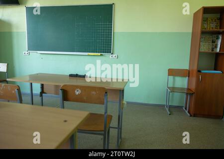 Classe vuota senza studenti in sedie e scrivanie scolastiche, Consiglio in Ucraina. Classe in vecchio stile Foto Stock