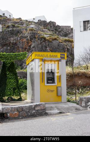 Pireo Bank, una multinazionale greca di servizi finanziari, bancomat giallo situato presso la spiaggia di St Paul's Bay sull'isola di Rodi, Grecia Foto Stock