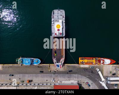 Vista aerea di un traghetto nel porto. I traghetti nel porto forniscono un collegamento vitale per i passeggeri e i veicoli, con una vista dall'alto Foto Stock