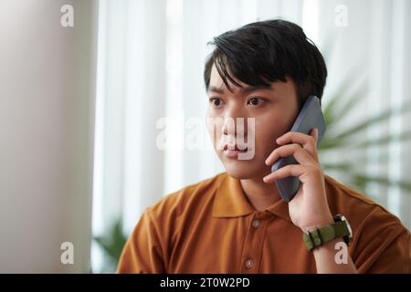 Sviluppatore preoccupato che chiami un collega che chiama l'amministratore di sistema Foto Stock