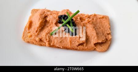 Brindisi con paté di scorpione, caviale e erba cipollina su sfondo bianco Foto Stock