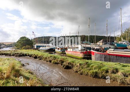 Villaggio di Gweek in Cornovaglia e deposito di imbarcazioni classiche sul fiume Helston, bassa marea, Inghilterra, Regno Unito, 2023 Foto Stock