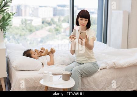 Madre con figlia malata che ha una videochiamata con il medico Foto Stock