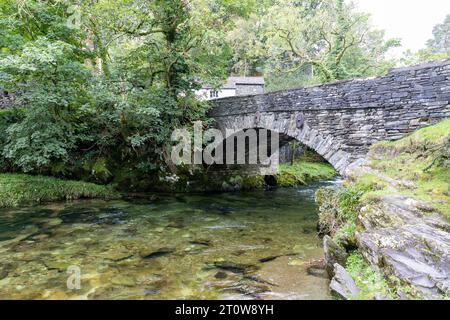 Elterwater Village e ponte nel Lake District, il fiume Brathay scorre sotto questo ponte classificato Grade 2 del XVIII secolo, Cumbria, Inghilterra, Regno Unito Foto Stock