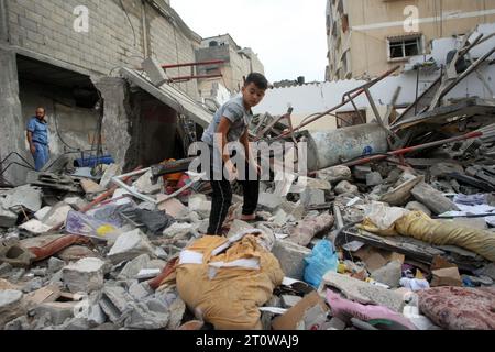 Rafah, Gaza. 9 ottobre 2023. I palestinesi siedono di fronte a un edificio livellato a seguito di attacchi aerei israeliani di notte su Rafah nella Striscia di Gaza meridionale, lunedì 9 ottobre 2023. L'esercito israeliano ha detto di aver colpito più di 500 obiettivi nella Striscia di Gaza in scioperi notturni. Foto di Ismael Mohamad/UPI. Crediti: UPI/Alamy Live News Foto Stock