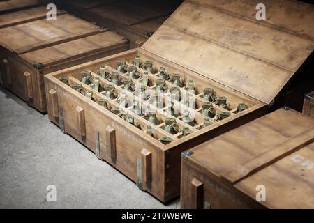 Scatole militari in legno piene di granate. I contenitori delle munizioni sono impilati uno accanto all'altro, con ogni scatola contenente un nu significativo Foto Stock