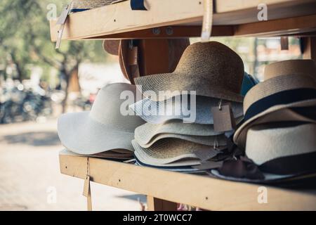 Italia - 7 agosto 2023: Cappelli da sole in una mensola di legno in vendita *** Sonnenhüte in einem Holz Regal zum Verkauf Foto Stock