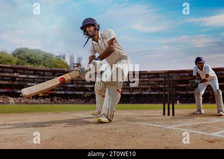 battitore del cricket che colpisce una velocità inversa durante una partita in campo Foto Stock