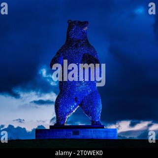 Scultura di orsi giganti in acciaio, Dunbear di Andy Scott illuminata di notte con un cielo scuro, Dunbar, East Lothian, Scozia, Regno Unito Foto Stock