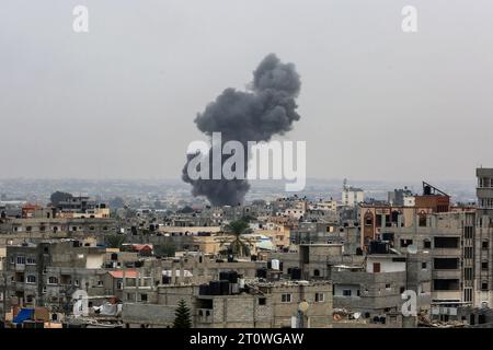 Rafah, territori palestinesi. 9 ottobre 2023. Da un edificio sorge un fumo denso a seguito di un attacco aereo israeliano vicino al Khan Yunis nella Striscia di Gaza meridionale. Israele ha pestato la Striscia di Gaza da una notte, mentre la lotta con militanti islamici di Hamas continua. Crediti: Abed Rahim Khatib/dpa/Alamy Live News Foto Stock