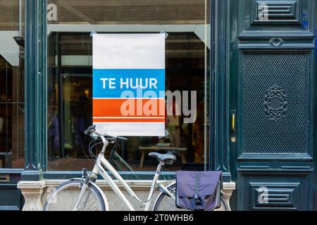 Cartello olandese con il testo "a noleggio" su una vetrina vuota con la bicicletta di fronte ad Arnhem, Paesi Bassi Foto Stock