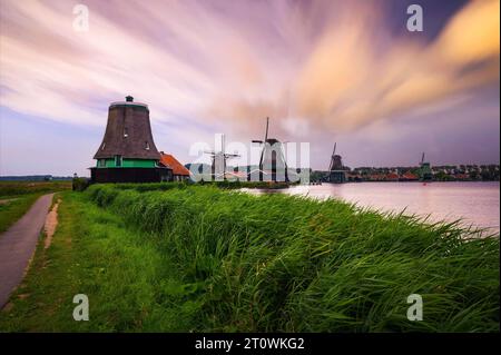 Tramonto al di sopra di case coloniche e mulini a vento di Zaanse Schans nei Paesi Bassi Foto Stock