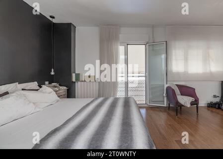 Camera doppia con bagno privato con balcone con vista, pareti in due colori, pavimenti in legno Foto Stock