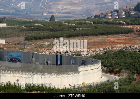 9 ottobre 2023, Libano, Adaisseh: Dipinti di bandiera palestinese e moschea di al-Aqsa sono visibili sul lato libanese di un muro israeliano eretto lungo il confine tra Libano e Israele nel villaggio meridionale di Adaisseh, dove l'insediamento israeliano di Mutelh è visto sulla destra. Le forze interinali delle Nazioni Unite nel Libano meridionale (UNIFIL) hanno esortato la massima moderazione al confine libanese con Israele in seguito alla massiccia escalation di violenza tra palestinesi e Stato ebraico. Foto: Marwan Naamani/dpa Foto Stock