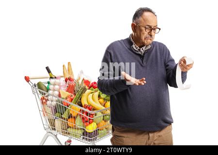 Uomo maturo confuso con un carrello che guarda una banconota isolata su sfondo bianco Foto Stock