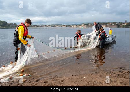 Berwick-upon-Tweed, Regno Unito. 9 ottobre 2023. Il personale dell’Agenzia per l’ambiente effettua un’indagine sulla popolazione ittica sull’estuario del fiume Tweed. Utilizzando una barca e reti da circuizione, ricordano i tradizionali metodi di pesca del salmone che catturano, contano, misurano e rilasciano il pesce per aiutare a comprendere gli stock ittici locali. Crediti: Julian Eales/Alamy Live News Foto Stock