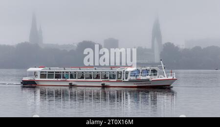 Amburgo, Germania. 9 ottobre 2023. Un piroscafo Alster naviga attraverso una leggera goccia sull'Alster esterno in condizioni atmosferiche nebulose. Credito: Markus Scholz/dpa/Alamy Live News Foto Stock