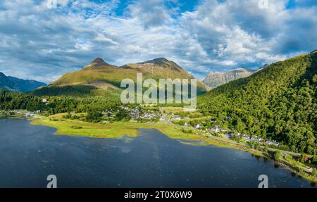 Panorama aereo del lago d'acqua dolce loch Leven con il villaggio di Glen Coe, sopra di esso, il Pap of Glencoe, Highlands, Scozia, alto 742 metri Foto Stock