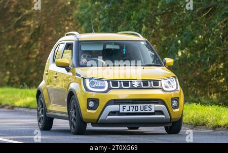 Milton Keynes, Regno Unito - 26 settembre 2023: 2020 auto elettrica ibrida Suzuki Ignis gialla che guida su una strada inglese Foto Stock