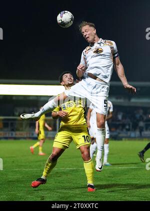 Josh Gordon di Burton Albion e Michael Morrison (a destra) del Cambridge United combattono per il pallone durante la partita Sky Bet League One al Pirelli Stadium di Burton. Data immagine: Lunedì 9 ottobre 2023. Foto Stock