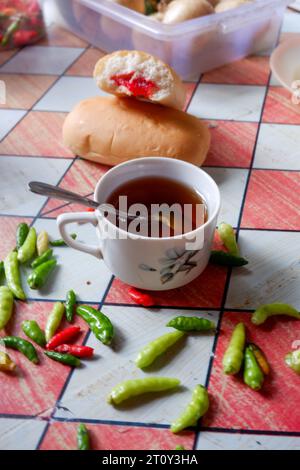 Foto di una tazza di tè con pane alla marmellata di fragole Foto Stock