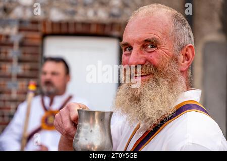 Una Morris Dancer del Brighton Morris Side che beve birra da Un Tankard tradizionale all'evento annuale "Dancing in the Old", Lewes, Sussex, Regno Unito Foto Stock