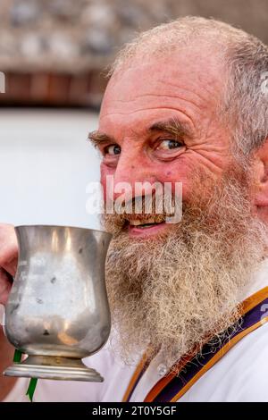 Una Morris Dancer del Brighton Morris Side che beve birra da Un Tankard tradizionale all'evento annuale "Dancing in the Old", Lewes, Sussex, Regno Unito Foto Stock