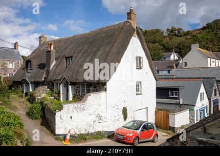 Cadgwith Village sulla costa della Cornovaglia, cottage con tetto in paglia nel villaggio con piccola auto intelligente, Cornovaglia, Inghilterra, Regno Unito Foto Stock