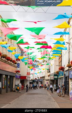 Falmouth, città costiera della Cornovaglia, Inghilterra, un'ampia gamma di negozi e negozi nel centro città con bandiere decorative per bunting, Inghilterra, Regno Unito, 2023 Foto Stock