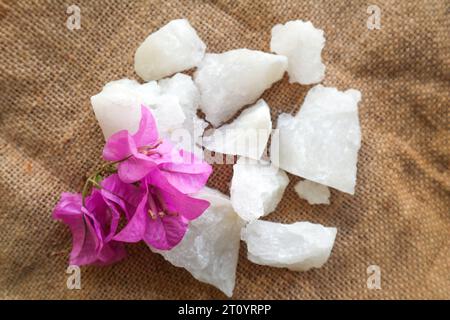 Alluminio, pietre di alluminio trasparenti o alluminio di potassio su piatto, decorate con fiori. Utile per trattamenti estetici e termali. Utilizzare per trattare gli odori del corpo sotto Foto Stock