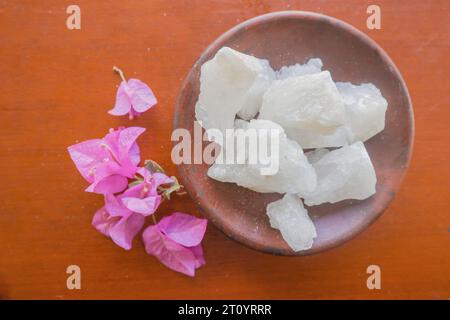 Alluminio, pietre di alluminio trasparenti o alluminio di potassio su piatto, decorate con fiori. Utile per trattamenti estetici e termali. Utilizzare per trattare gli odori del corpo sotto Foto Stock