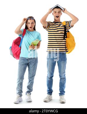 Studenti scioccati con zaini e libri isolati su sfondo bianco Foto Stock