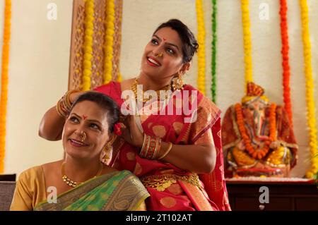 Madre e figlia guardano in alto durante Ganesh Chaturthi una festa celebrata nel Maharashtra ( India occidentale ) Foto Stock