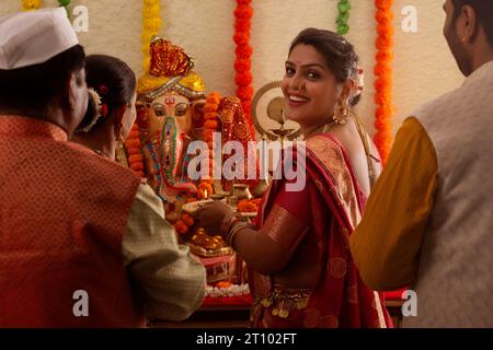 Famiglia Maharashtrian che prega il Signore Ganesha in occasione di Ganesh Chaturthi Foto Stock