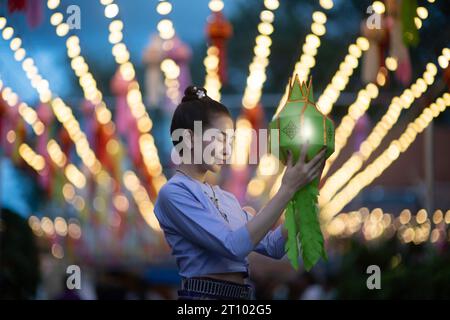 Bellissime donne asiatiche che tengono una tradizionale lanterna di carta durante il festival delle lanterne di Yi peng al Wat Phra That Hariphunchai, provincia di Lamphun, Thailandia. Foto Stock