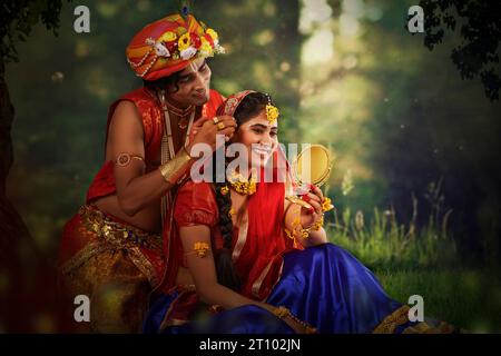 Giovane uomo e donna vestiti come Radha e Krishna e romantici in occasione di Janmashtami Foto Stock