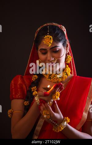 Giovane donna vestita da Lord Radha e tenendo un diya in occasione di Janmashtami Foto Stock