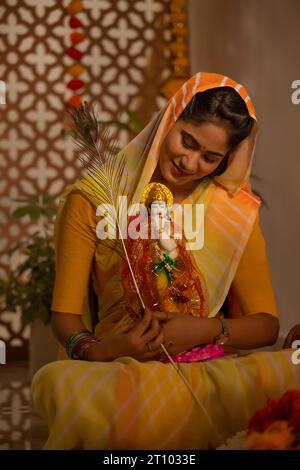 Donna che festeggia Janmashtami a casa Foto Stock