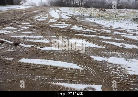 Piste per auto su una strada innevata. Strada sdrucciolevole, pericolo, rischio di slittamento. Tracce di battistrada per pneumatici invernali. Foto Stock