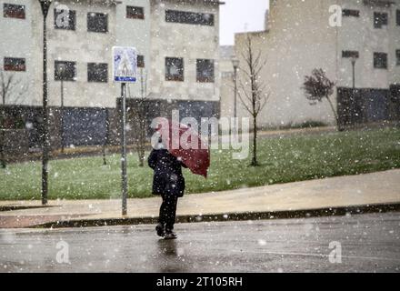 Dettaglio della persona anziana che cammina sotto la neve in una giornata invernale Foto Stock