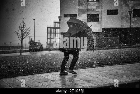 Dettaglio della persona anziana che cammina sotto la neve in una giornata invernale Foto Stock