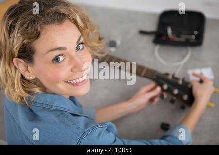 donna che ripara una chitarra Foto Stock