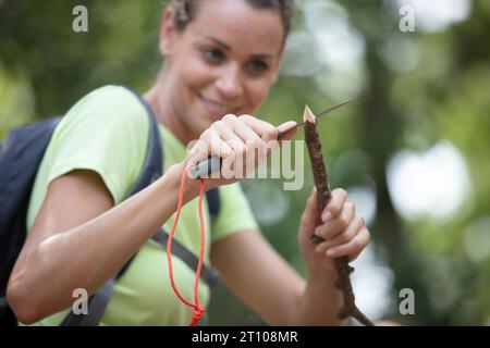 una donna giardiniera taglia un pezzo di legno Foto Stock