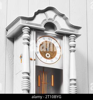 Un bellissimo orologio vintage in legno bianco, con intricati intagli e delicati dettagli, pende graziosamente su una parete luminosa fatta di tavole rustiche. Il suo ele Foto Stock