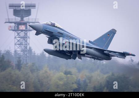 Laage, Germania. 10 ottobre 2023. Uno dei sei Eurofighter della Bundeswehr decolla in un volo della durata di diverse ore per un'esercitazione militare in Giordania. Per un'esercitazione militare pianificata da tempo, l'aeronautica militare tedesca sta trasferendo aerei da caccia e soldati in Giordania. Lì, parteciperanno all'esercitazione trinazionale "Desert Air" insieme alle forze aeree giordane e statunitensi. Credito: Jens Büttner/dpa/Alamy Live News Foto Stock