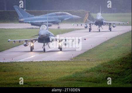 Laage, Germania. 10 ottobre 2023. Tre su un totale di sei Eurofighter della Bundeswehr partono in taxi per un'esercitazione militare in Giordania che durerà diverse ore. Per un'esercitazione militare pianificata da tempo, l'aeronautica militare tedesca sta trasferendo aerei da caccia e soldati in Giordania. Insieme alle forze aeree giordane e statunitensi, parteciperanno all'esercitazione trinazionale "Desert Air". Credito: Jens Büttner/dpa/Alamy Live News Foto Stock