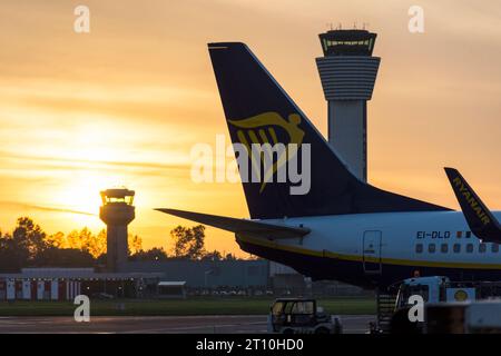 Aeroporto di Dublino, Irlanda, torri di controllo e tramonto e aerei in stand. Foto Stock