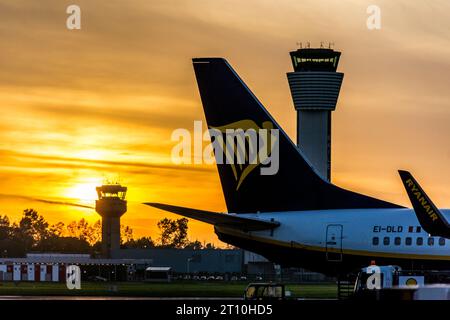 Aeroporto di Dublino, Irlanda, torri di controllo e tramonto e aerei in stand. Foto Stock