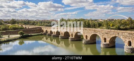 Panorama dello storico ponte romano che si riflette nel fiume Guadiana a Merida, Spagna Foto Stock