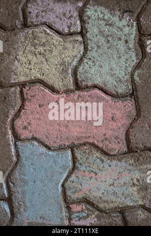 Disegni con gesso sui marciapiedi. Un bellissimo gesso colorato e geometrico che disegna dall'alto. Pavimentazione dipinta con gessetti multicolori. Vista dall'alto. Foto Stock